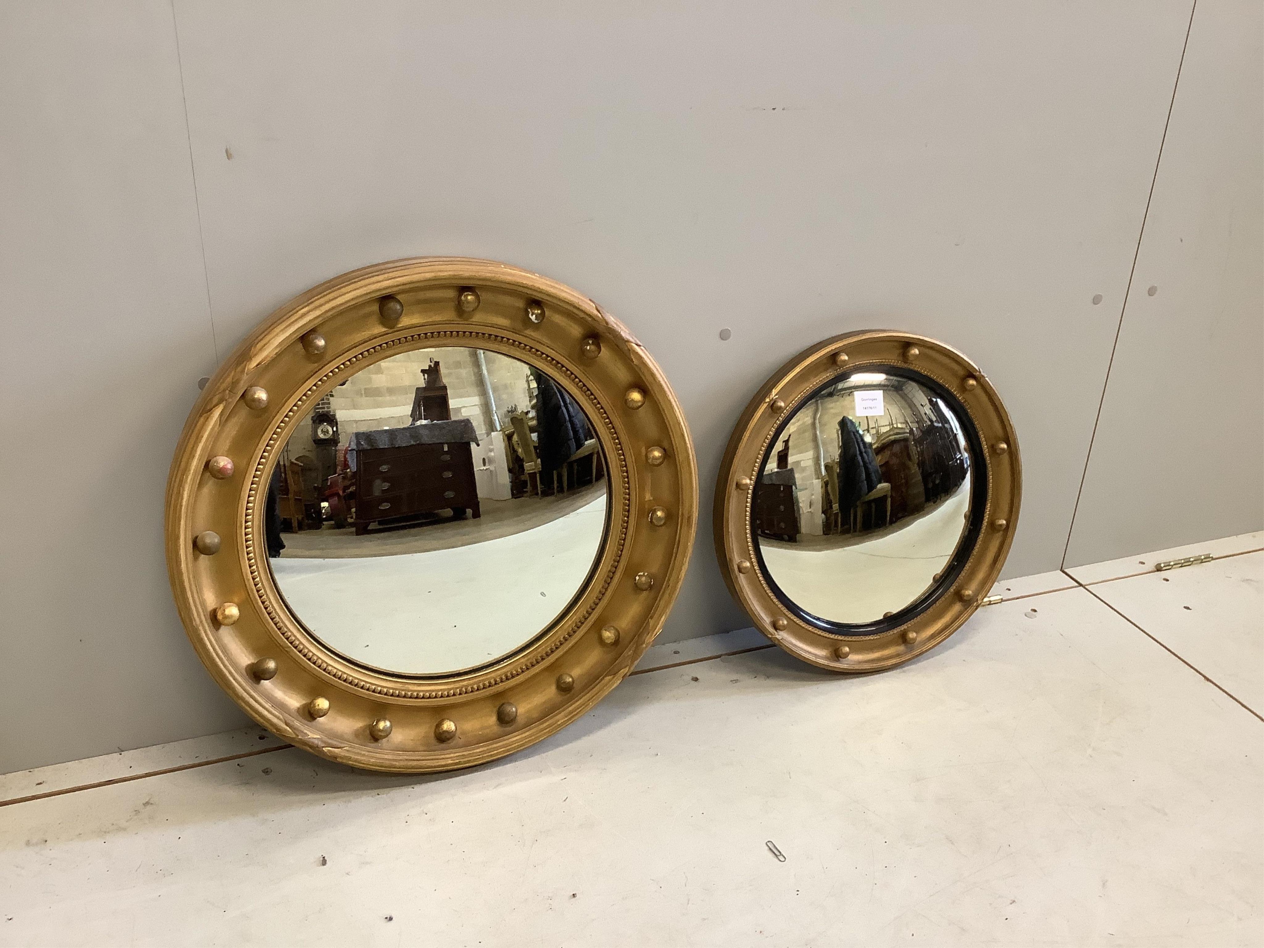 Two Regency style circular giltwood and composition convex wall mirrors, larger diameter 58cm. Condition - fair